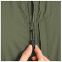 Close-up of an olive green zippered fishing vest with a black zipper pull being pulled by a person's fingers.