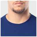 Close-up of a person wearing a blue shirt with a neutral background