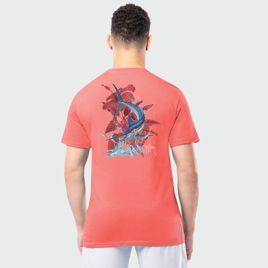 Person wearing a coral t-shirt with a marlin fish and leaf design on the back, standing against a white background