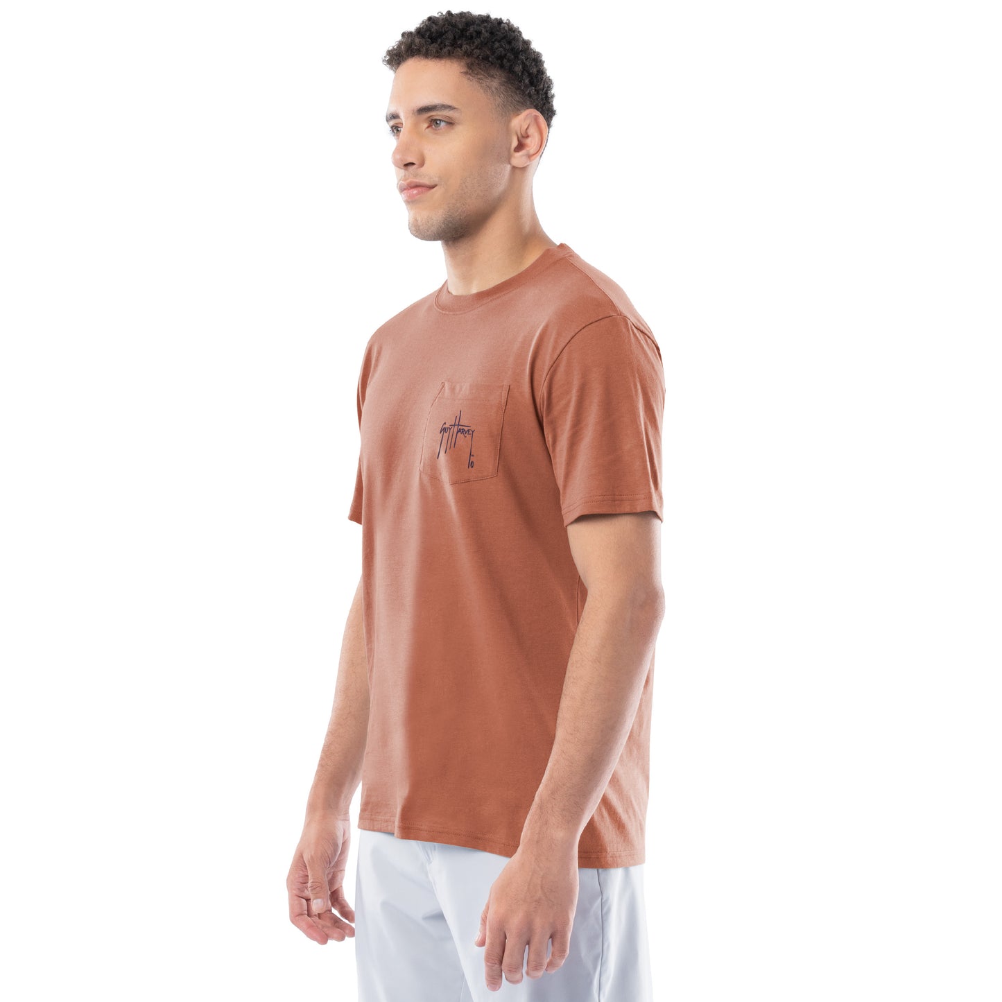 Man wearing a brown t-shirt with a small Guy Harvey logo on a white background