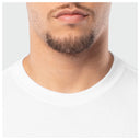 Close-up of a person wearing a white t-shirt with a neutral background
