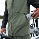 A man wearing a Guy Harvey Angler Edge vest in olive green.