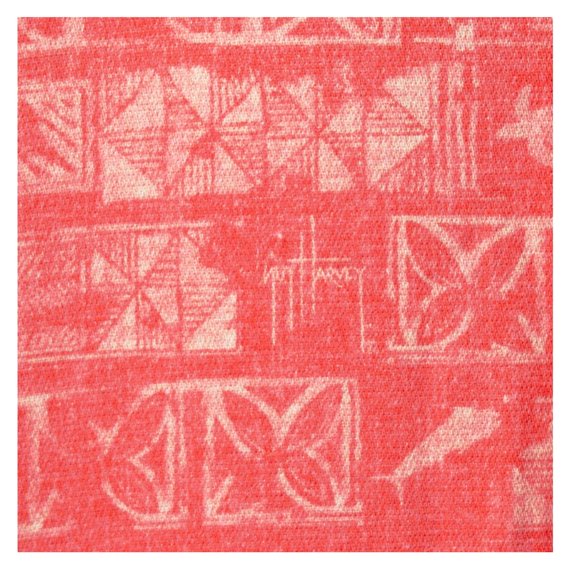 Close-up of coral red Guy Harvey Aztec print pattern with signature artwork.