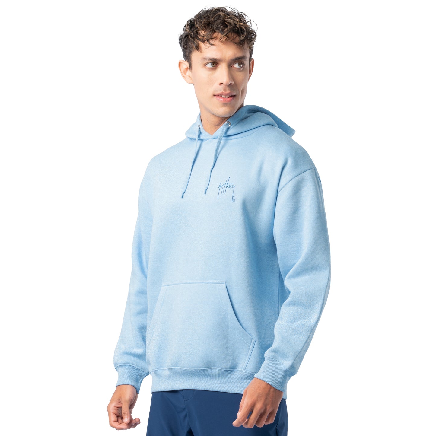 Side-front view of a man wearing a light blue Guy Harvey fishing fleece hoodie showing the chest logo.