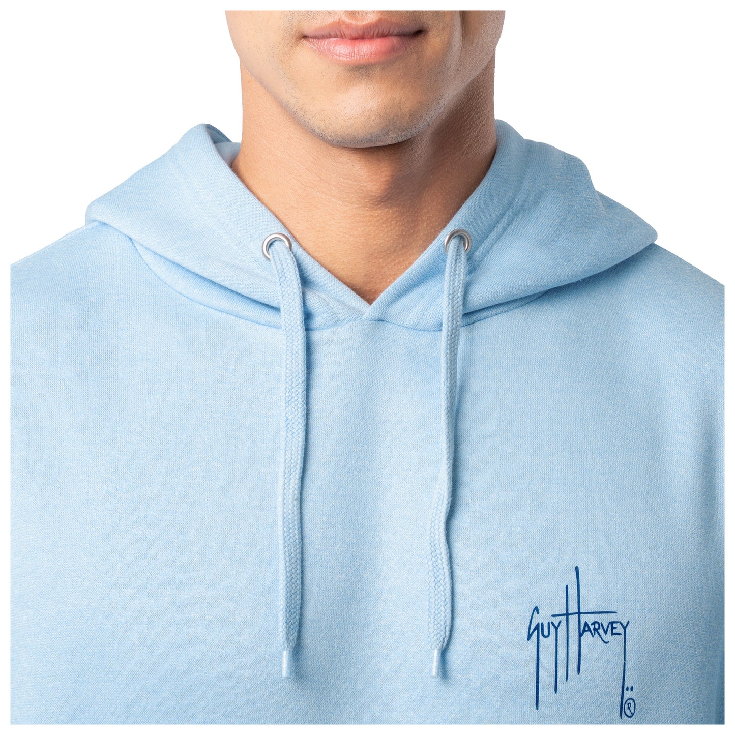 Close-up of the white Guy Harvey logo on the chest of a light blue fishing fleece hoodie.