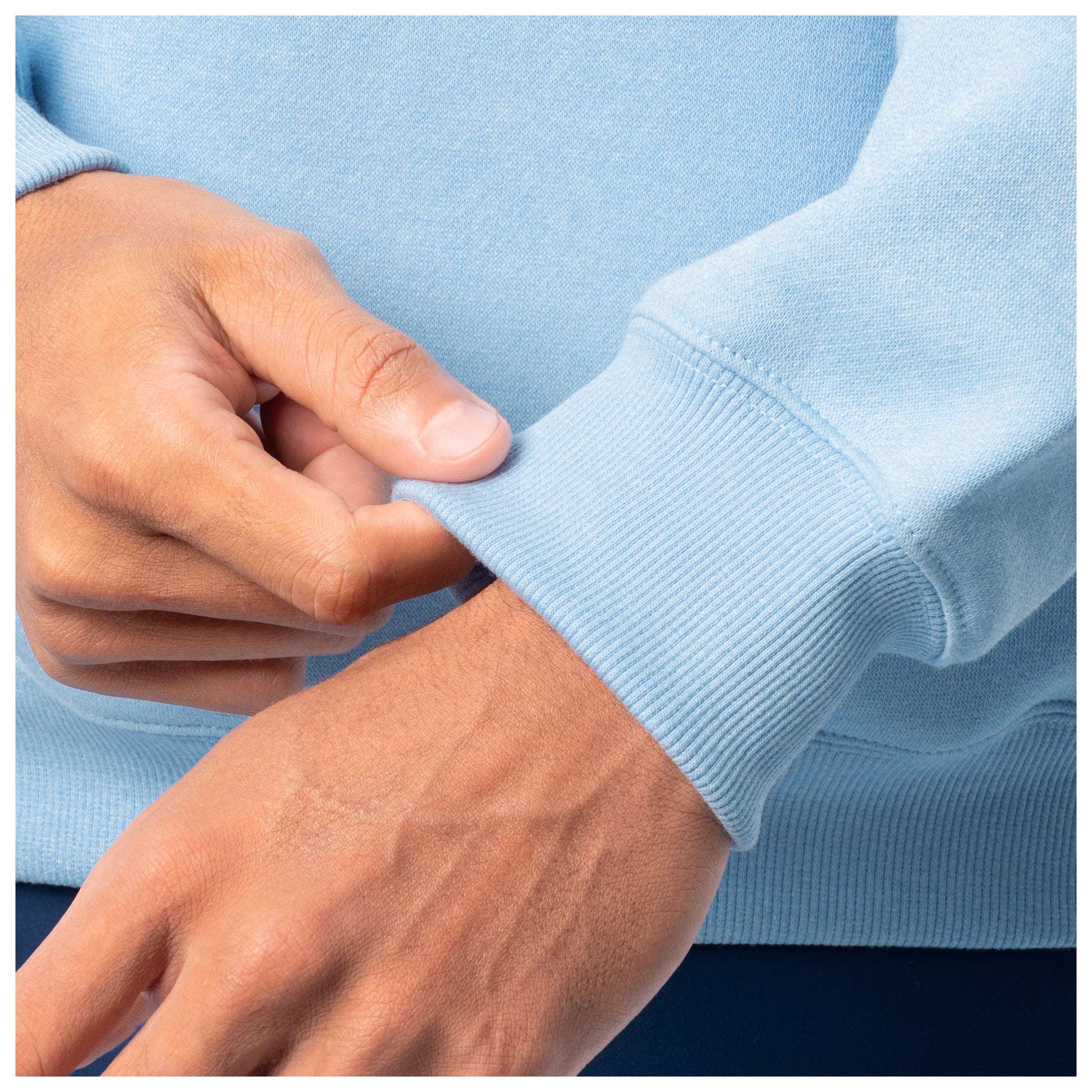Close-up of sleeve cuff detail on a light blue Guy Harvey fishing fleece hoodie.