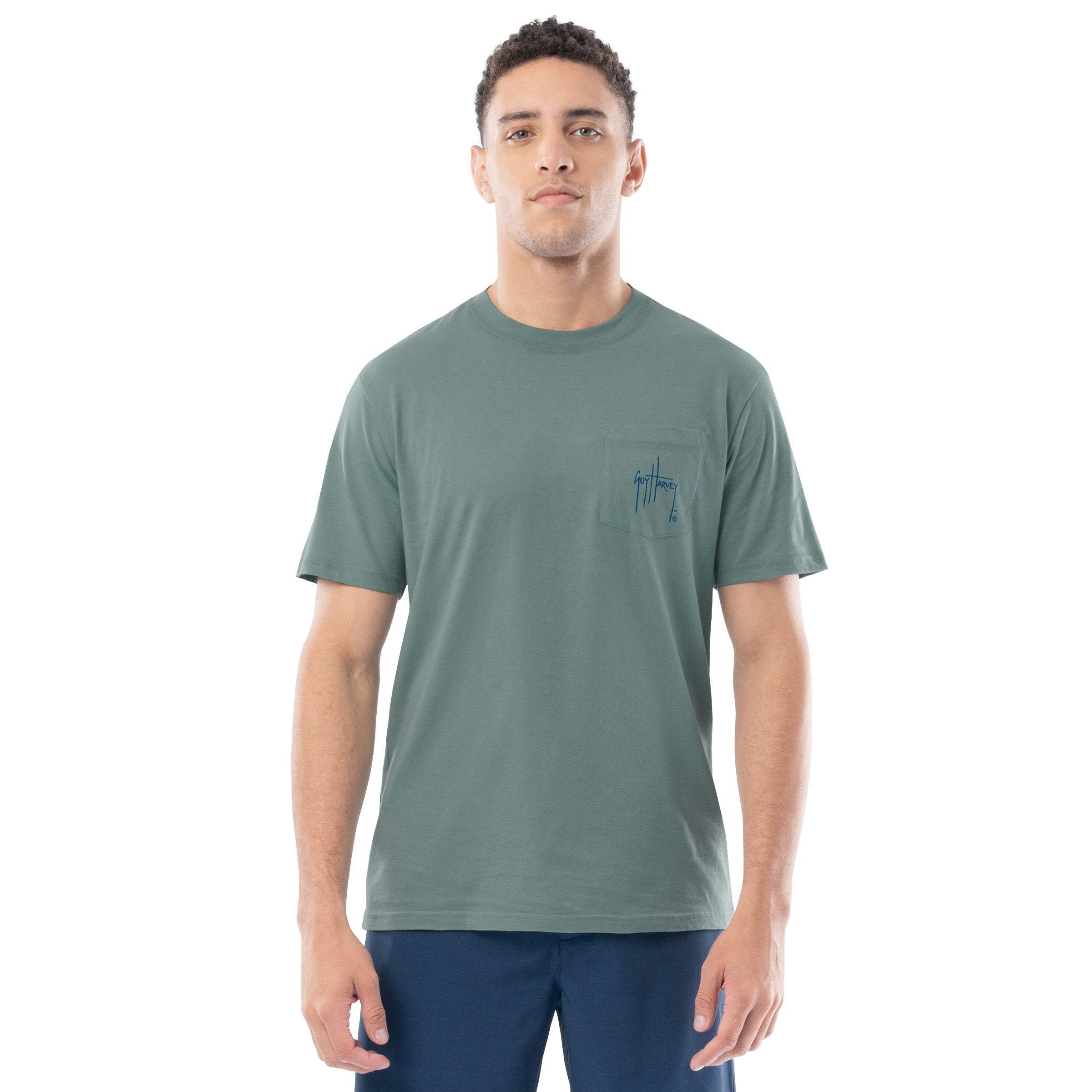 Man wearing a green t-shirt with a small logo on a white background