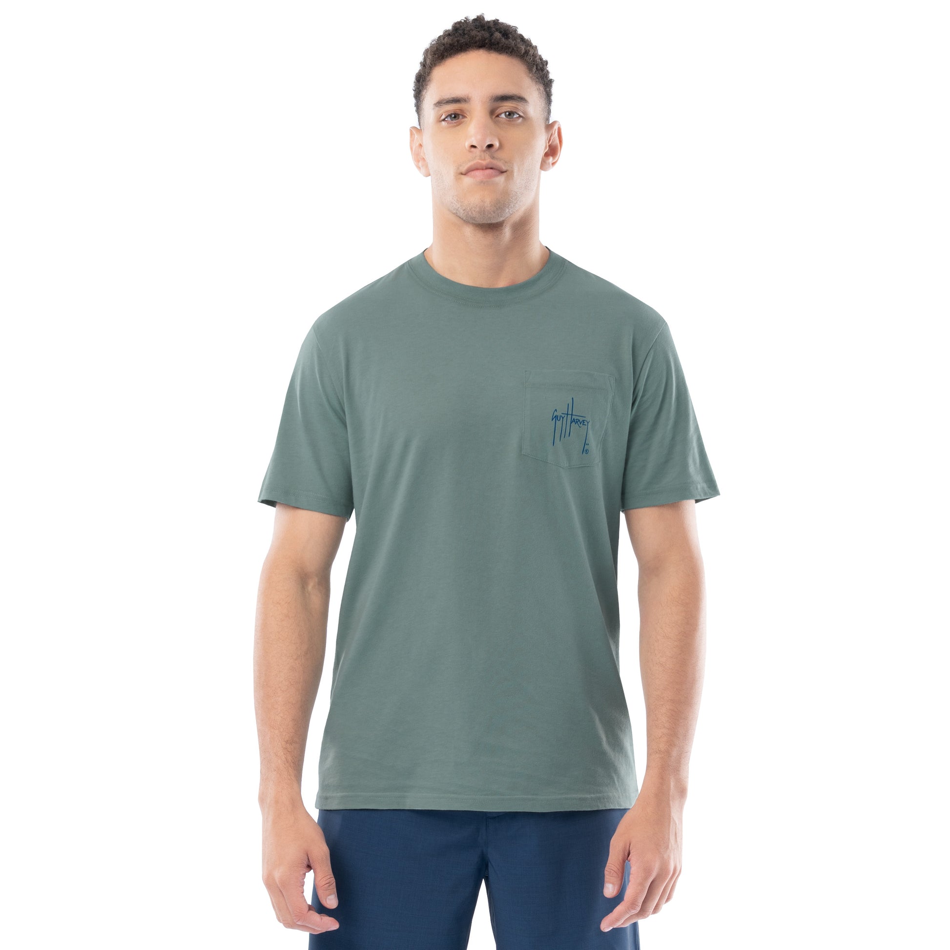 Man wearing a green t-shirt with a small logo on a white background