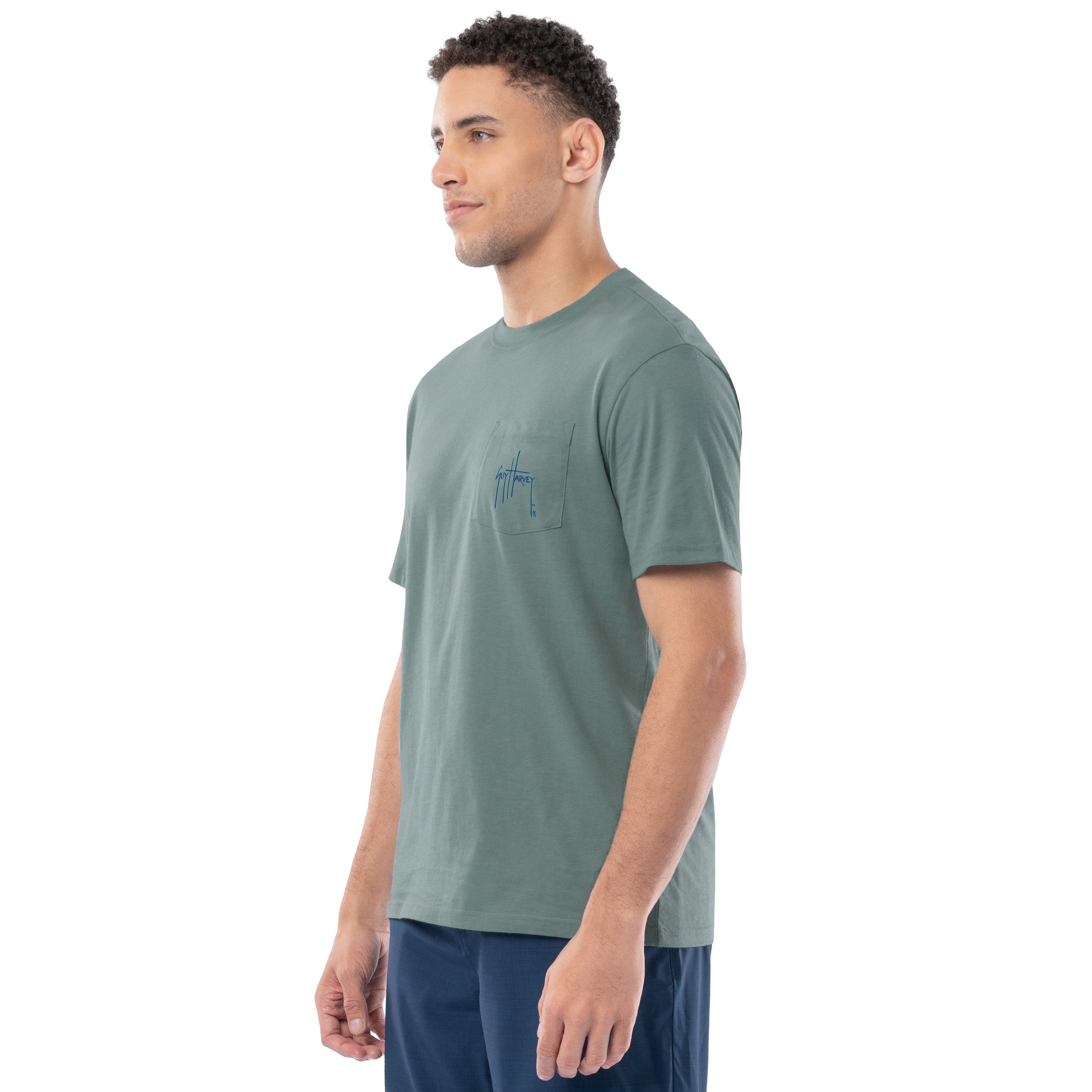 Man wearing a green t-shirt with a small logo on a white background