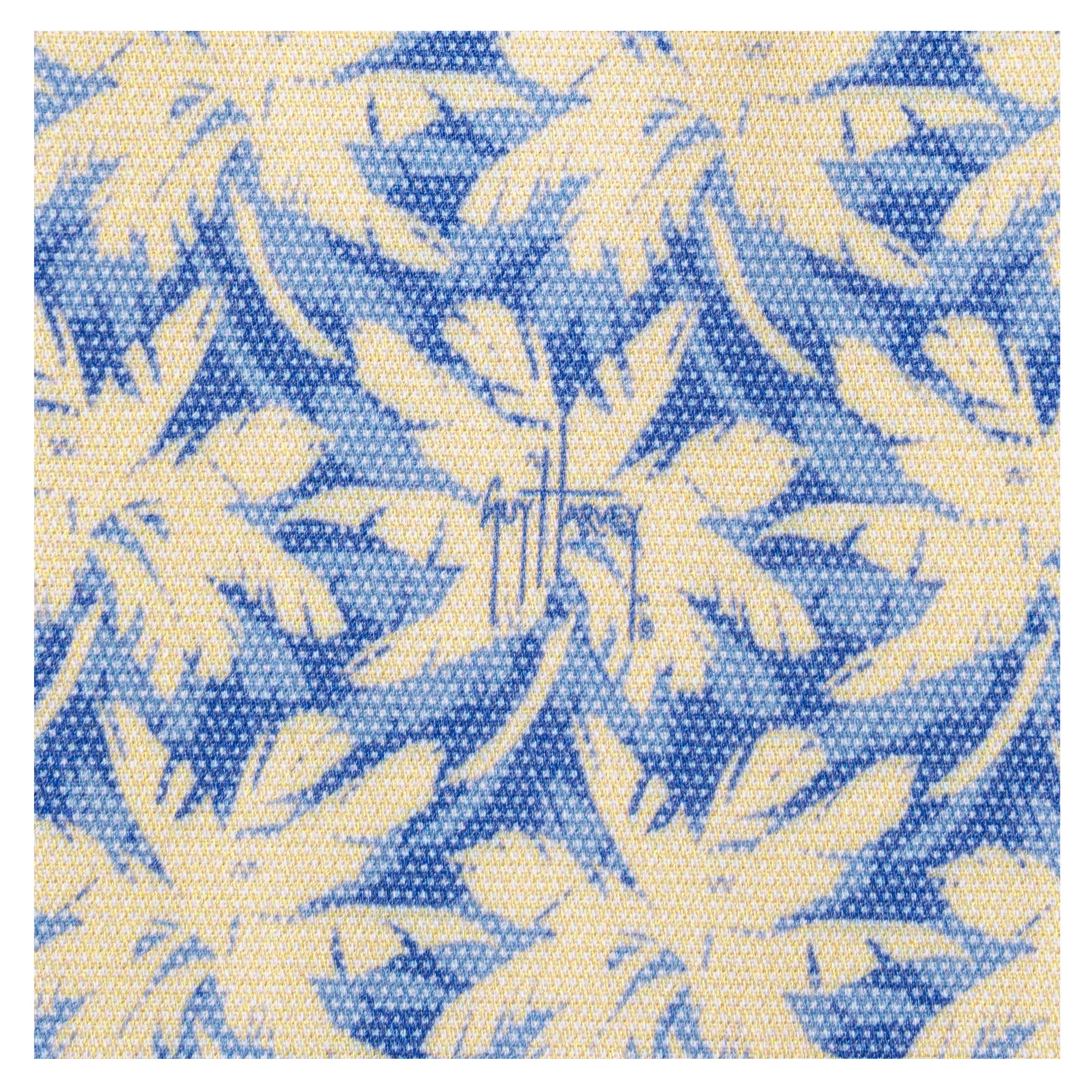 Close-up of Guy Harvey signature on blue and sand palm print fabric.