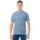 Man wearing a light blue t-shirt with a small logo on a white background