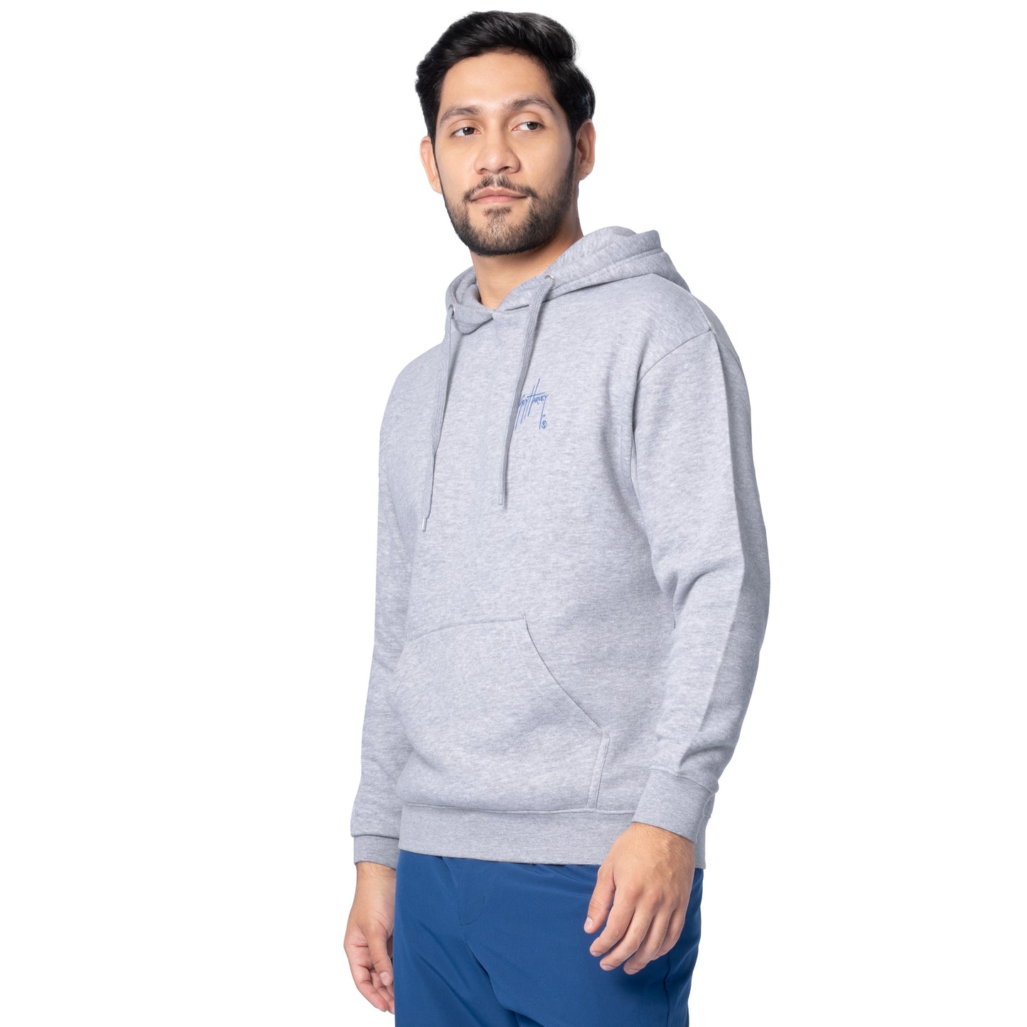 Side-front view of a man wearing a light gray Guy Harvey fishing fleece hoodie showing the chest logo.