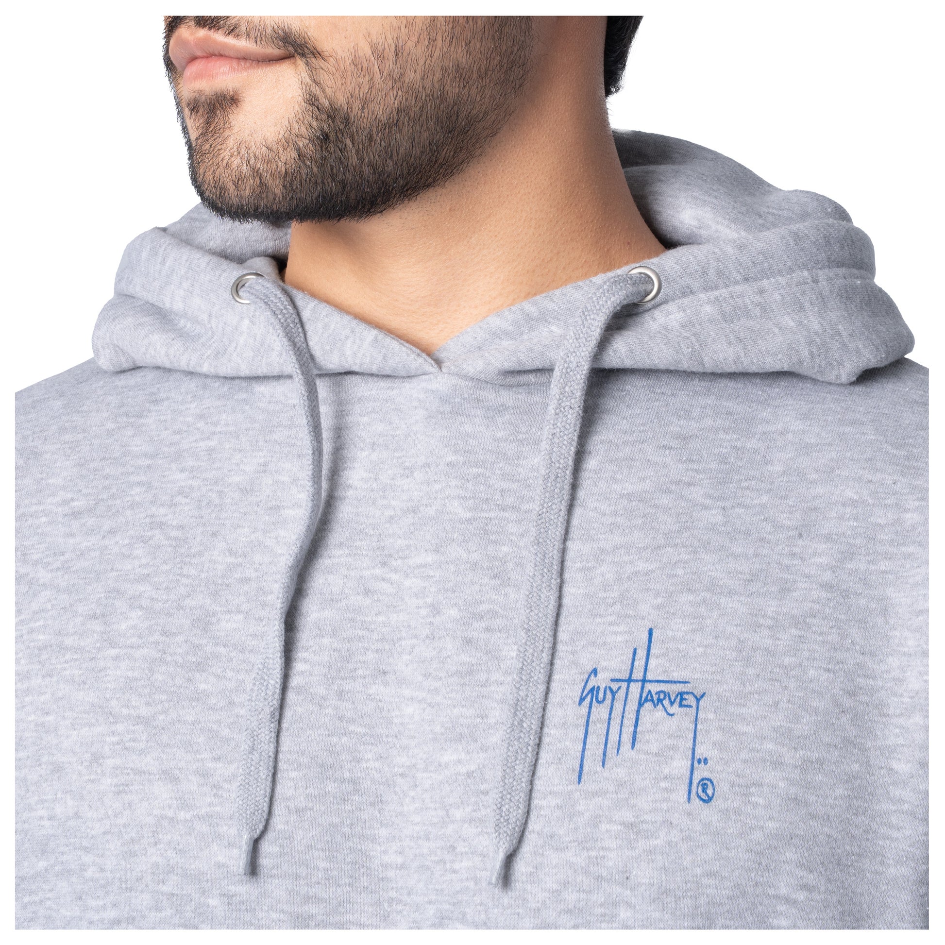 Close-up of the blue Guy Harvey logo on the chest of a light gray fishing fleece hoodie.