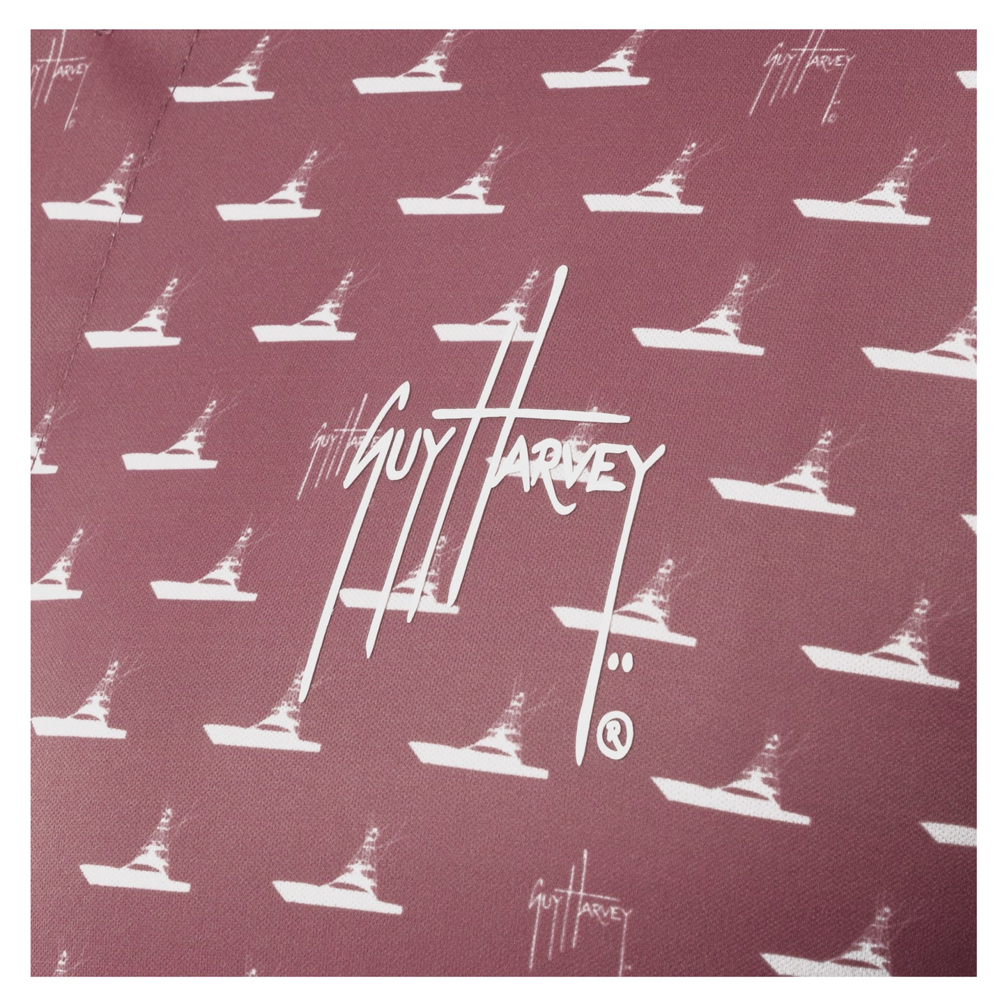 Detail of white Guy Harvey signature logo and boat print on red wine fabric.