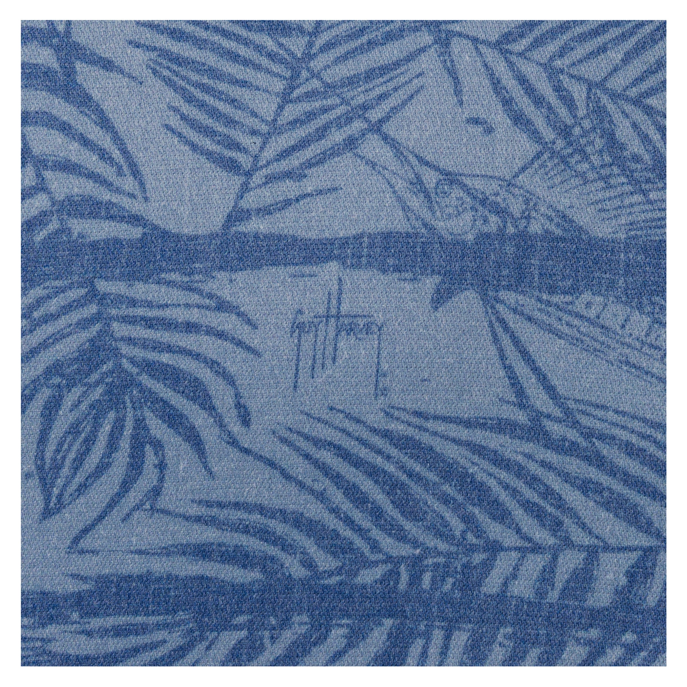 Close-up of Guy Harvey signature within Sandbar print on denim blue fabric.