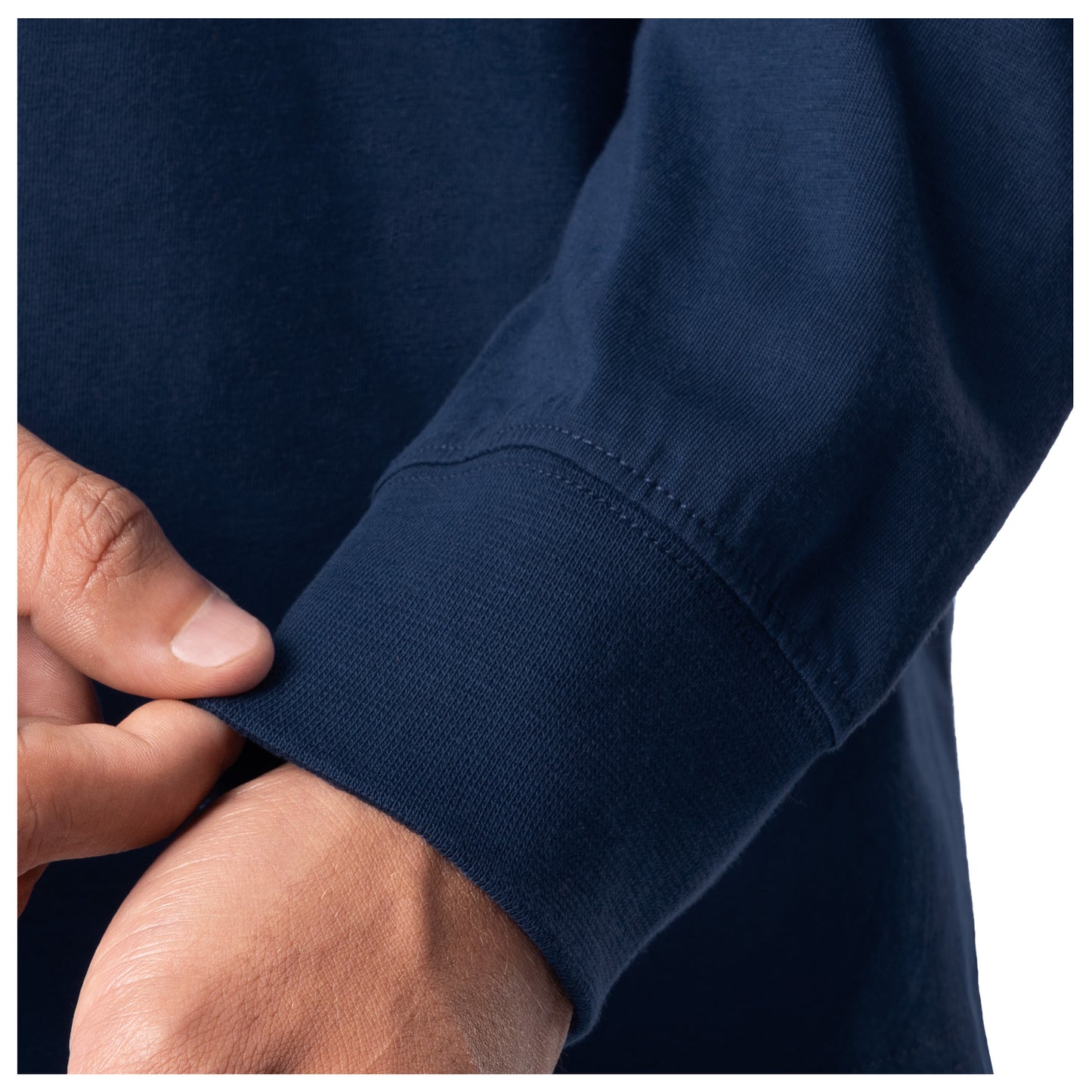 Close-up of a navy blue shirt with rolled-up sleeve and hand adjusting it.
