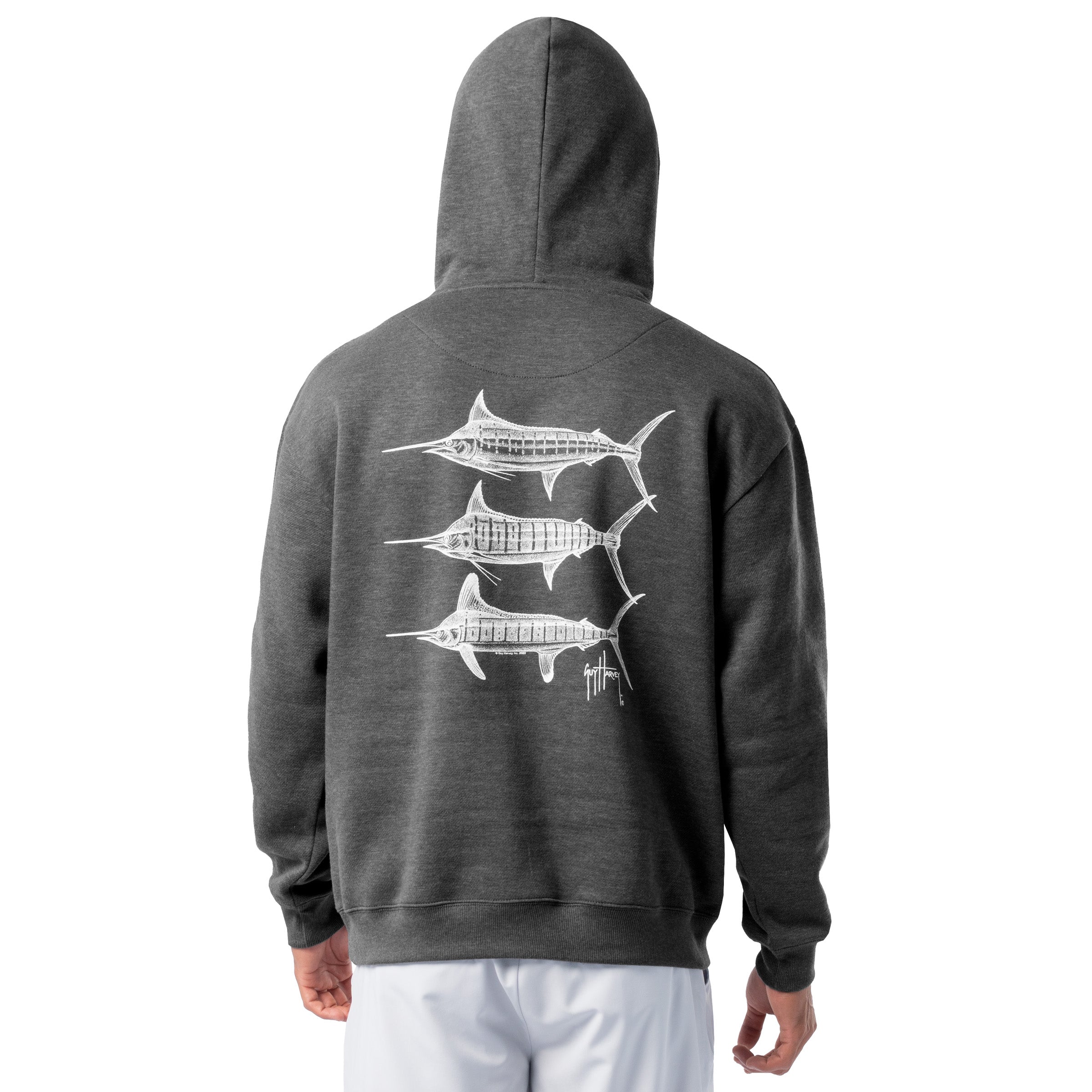Back view of a man wearing a dark gray Guy Harvey fishing fleece hoodie featuring three white marlin line-art graphics on the back.