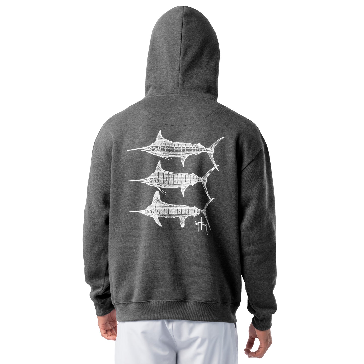 Back view of a man wearing a dark gray Guy Harvey fishing fleece hoodie featuring three white marlin line-art graphics on the back.