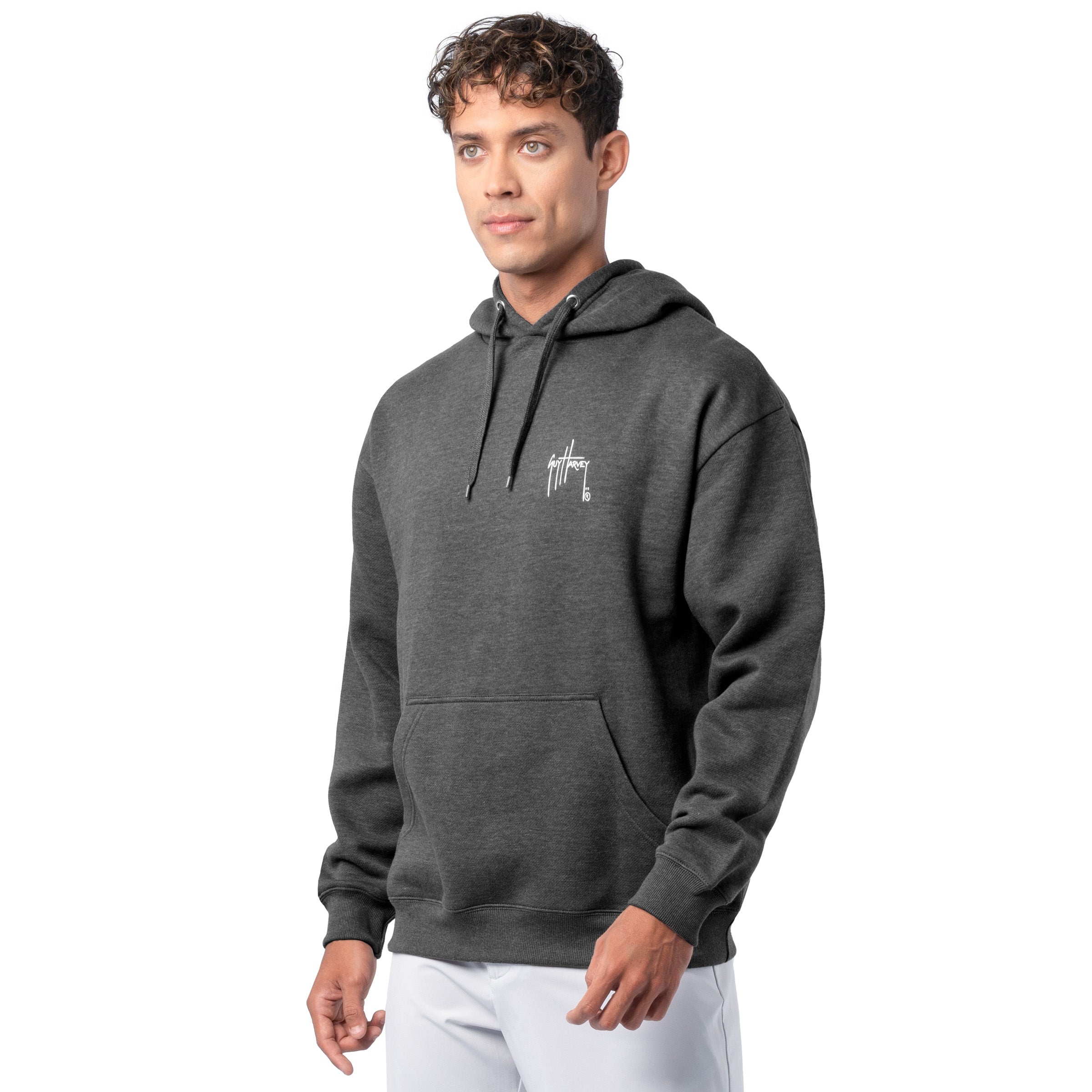 Side-front view of a man wearing a dark gray Guy Harvey fishing fleece hoodie with the white Guy Harvey logo on the chest.