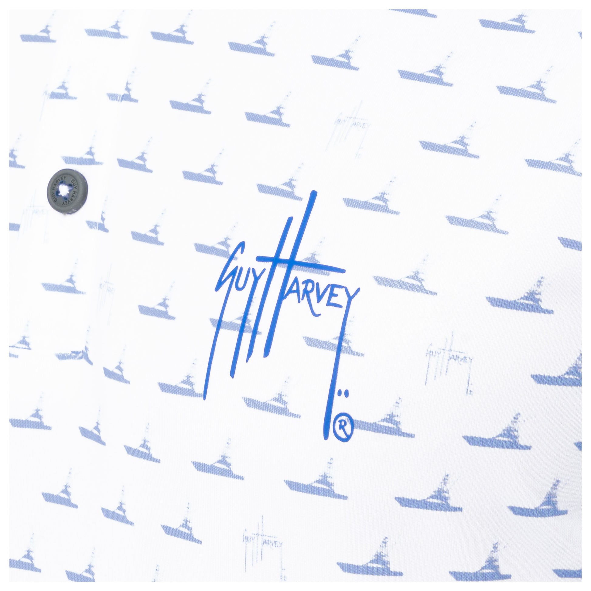 Detail of blue Guy Harvey signature logo and boat print on white performance fabric.