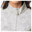 Close-up of a woman wearing a light gray and white camouflage patterned zip-up athletic jacket with a high collar.