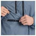 Close-up of a man wearing a blue-gray lightweight jacket, demonstrating a zippered pocket on the front.