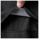 Close-up of a black garment being opened by a hand, showing a textured black mesh interior lining.
