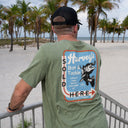 A male wearing A olive green Guy Harvey Threadcycled T-Shirt with a freshwater graphic
