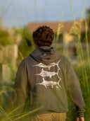 Person wearing a hoodie with fish design in a natural setting