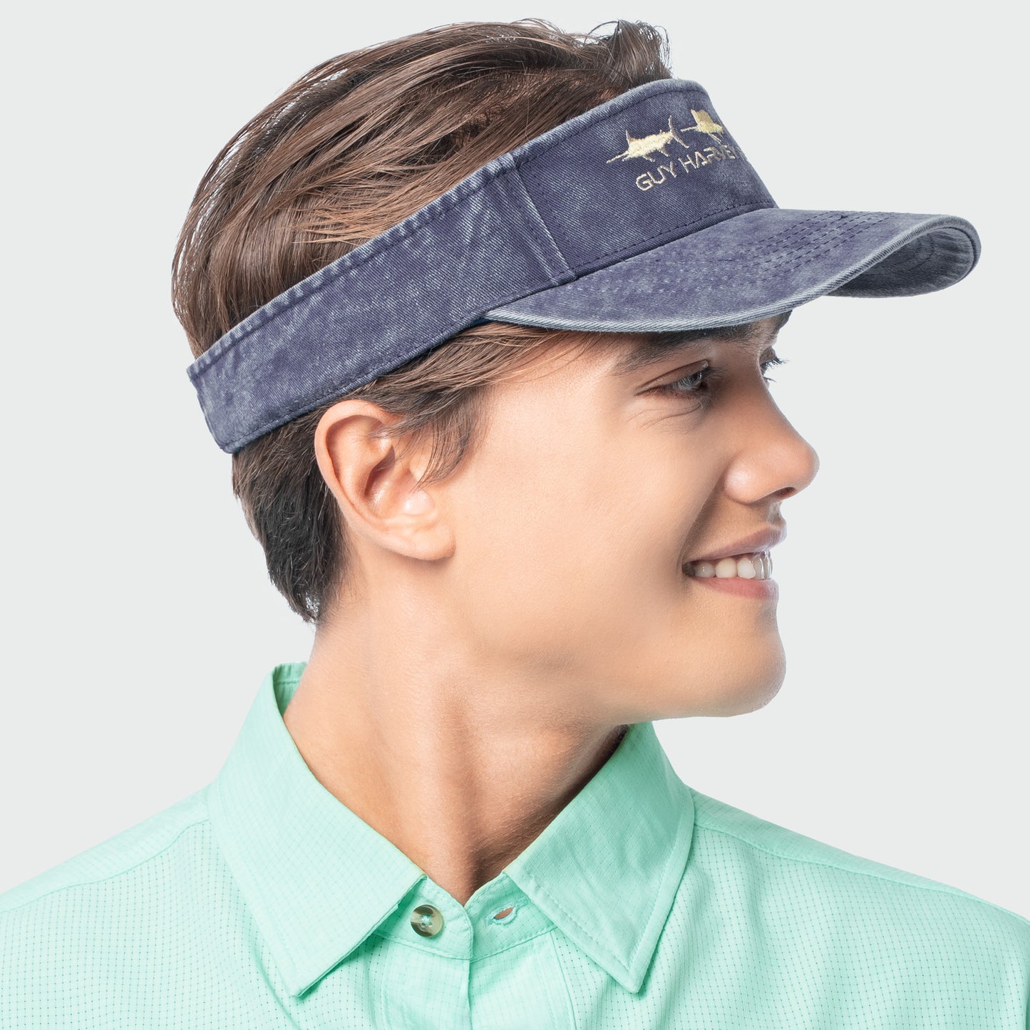 Person wearing a navy visor with a brand logo on a light gray background