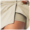Close-up of a person wearing a light beige matching set, featuring a lightweight open-front top and coordinating shorts, with the top being pulled up slightly by a hand.