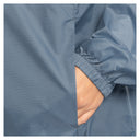 Close-up of a person wearing a blue-gray grid-patterned jacket, with a hand tucked into a side pocket and the elasticized cuff visible.