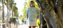 A woman wearing a green Guy Harvey Coastal Wash tee with seashells, turtles, and seahorses.