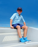 A child in sunglasses smiling on a boat
