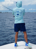 Person wearing a Guy Harvey shirt and shorts on a boat with ocean view