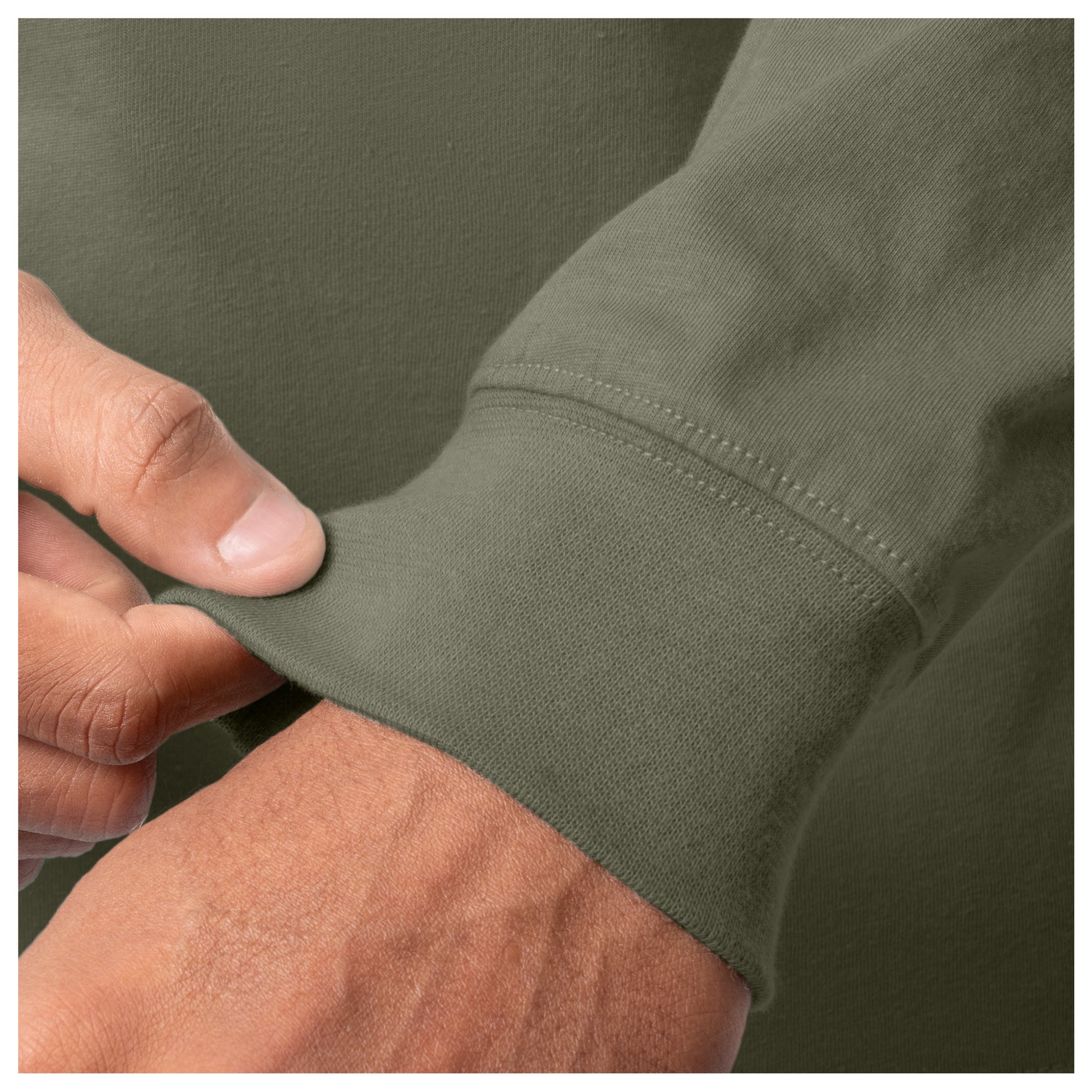 Close-up of a person adjusting the sleeve of a green jacket.