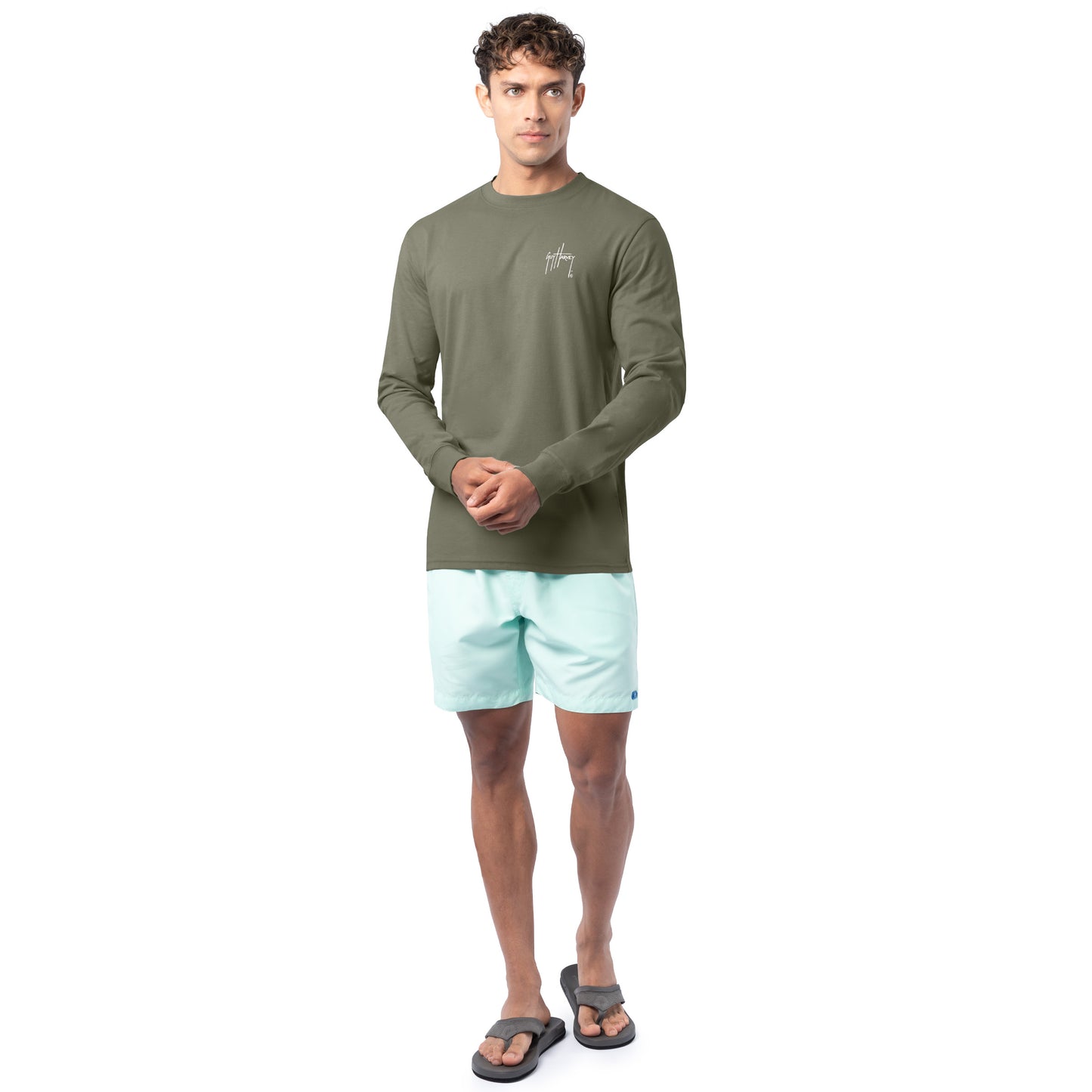 Lifestyle photo of model wearing Guy Harvey Men’s Crab Stamp Lightweight Long Sleeve Tee by the coast