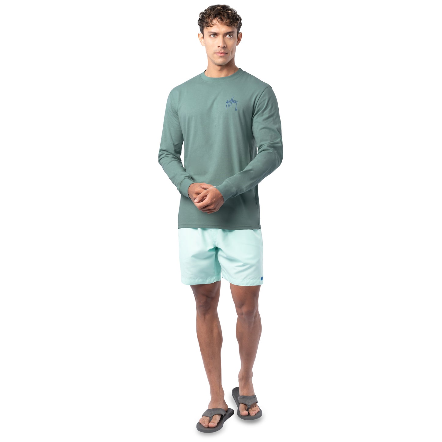 Lifestyle photo of model wearing Guy Harvey Men’s Volcano Lightweight Long Sleeve Tee near the coast