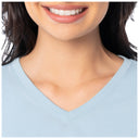 Close-up of a person wearing a light blue V-neck shirt with a blurred background