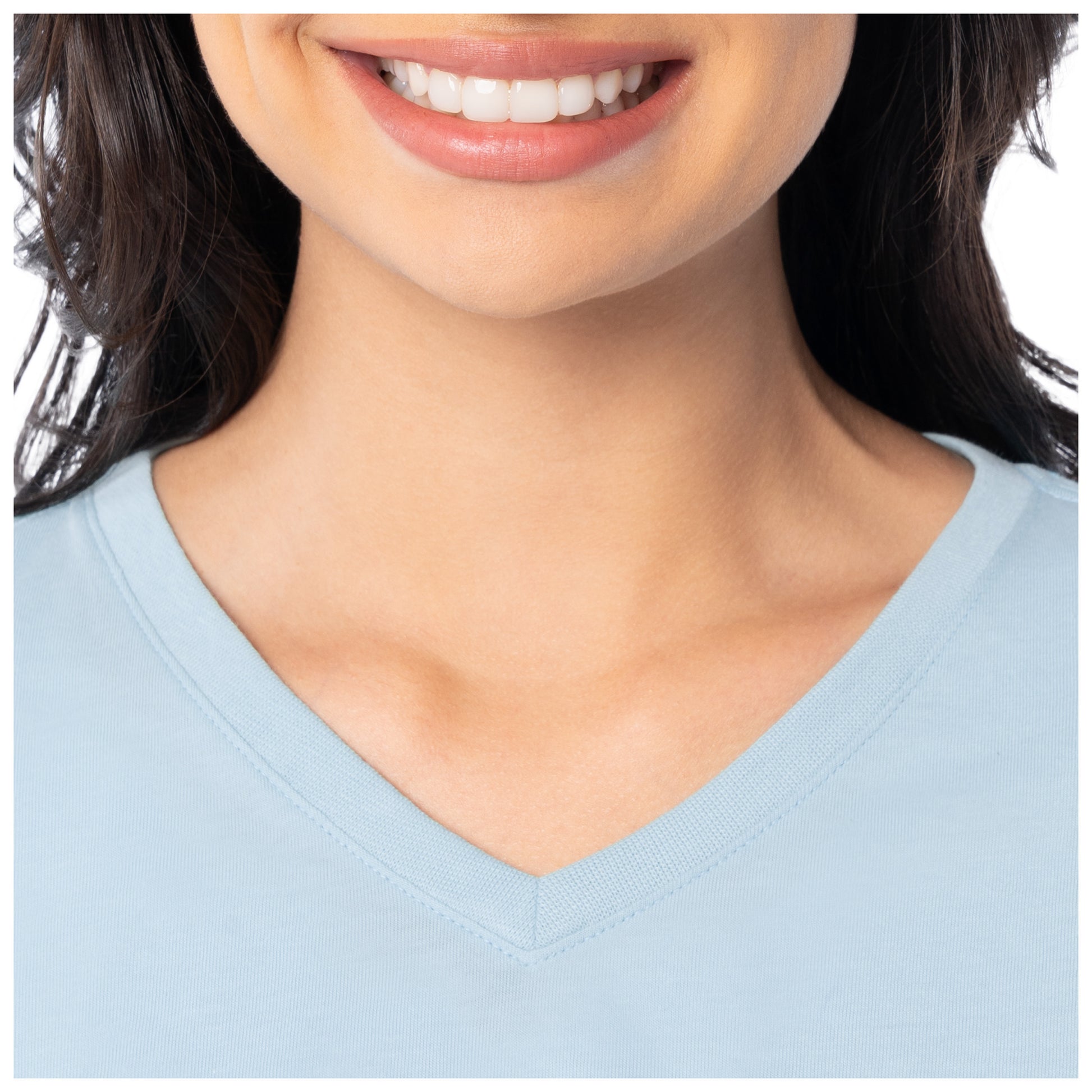 Close-up of a person wearing a light blue V-neck shirt with a blurred background