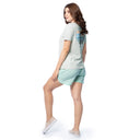 Woman wearing a light gray t-shirt and light green shorts on a white background