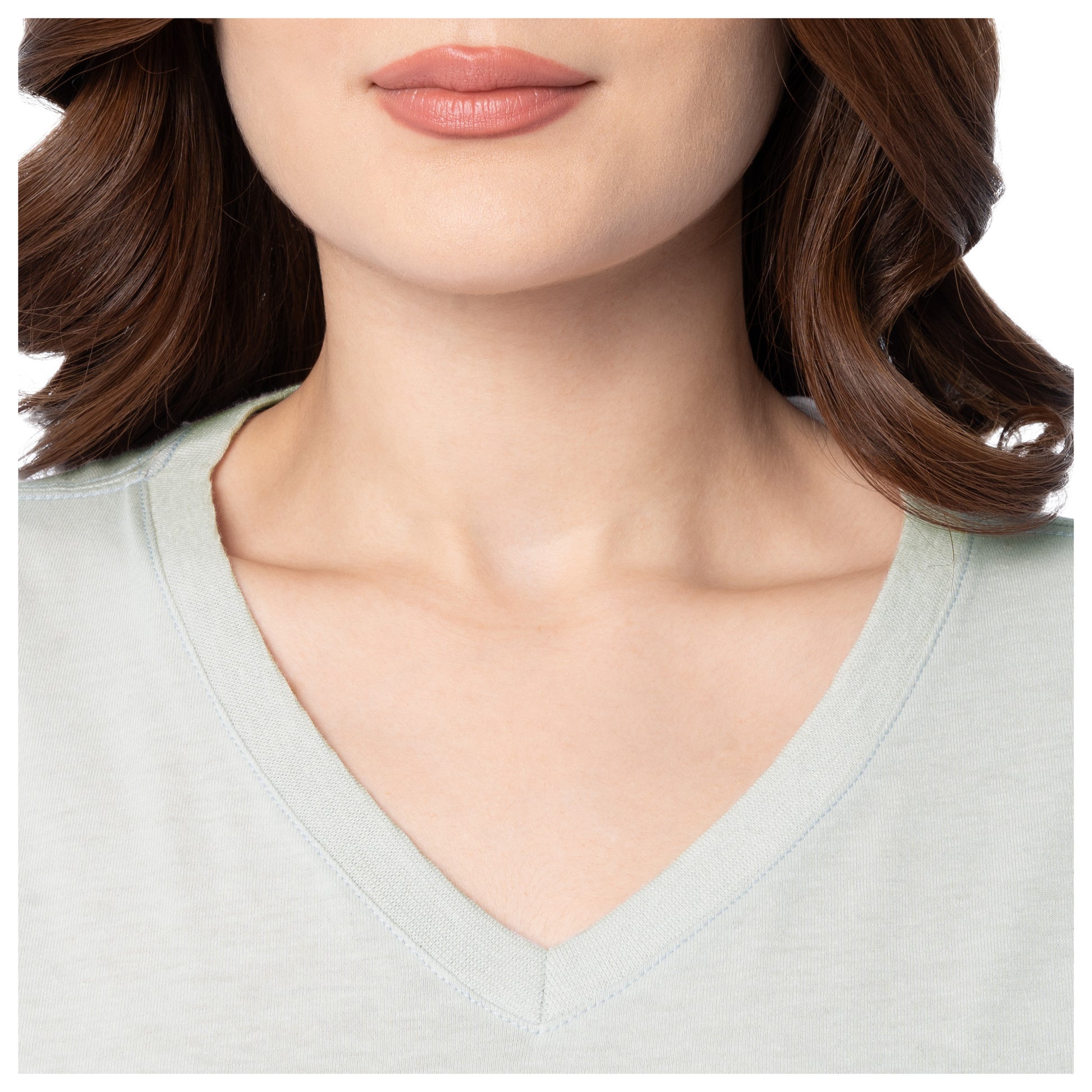 Close-up of a person wearing a light gray V-neck shirt with a blurred background