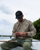 A man wearing a Guy Harvey Navigator Fleece pullover hoodie in camo pattern.